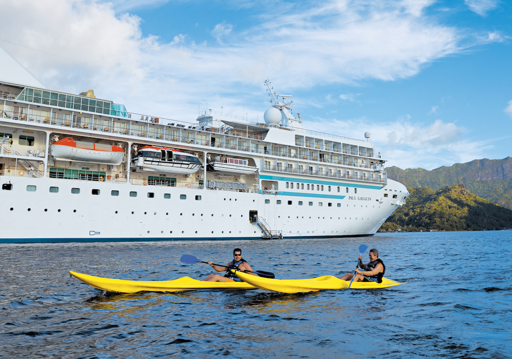 Kayaking alongside cruise ship Paul Gauguin